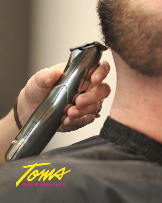 close-up of a person getting his beard trimmed